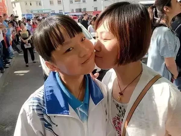 “第一天考完,媽媽在校門口親了女兒一口。”(圖源:青島日報)