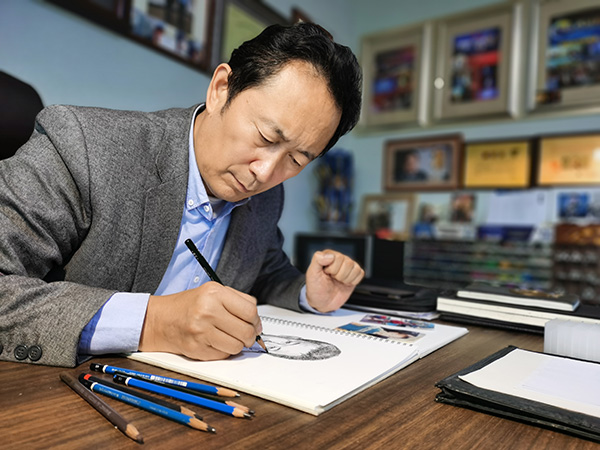 林宇辉为被拐儿童画像。通常情况下,他要根据被拐儿童小时候的照片,绘出其长大成人的画像。