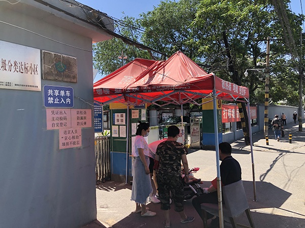 北京某小区外,执勤人员严守大门。澎湃新闻记者 汤琪 图
