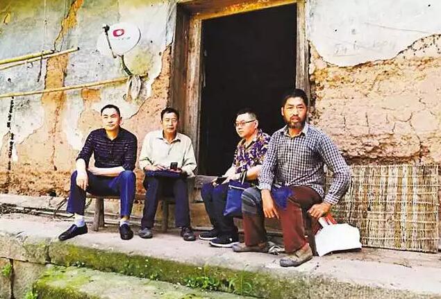 杨骅(右二)生前在走访贫困群众。金鸡镇政府供图