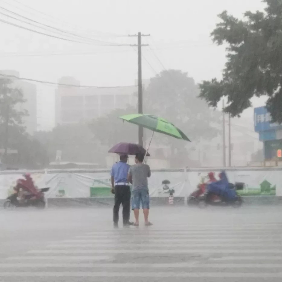 广西一男子大雨中为交通协管员撑伞,这位"撑伞哥"可有人认识?