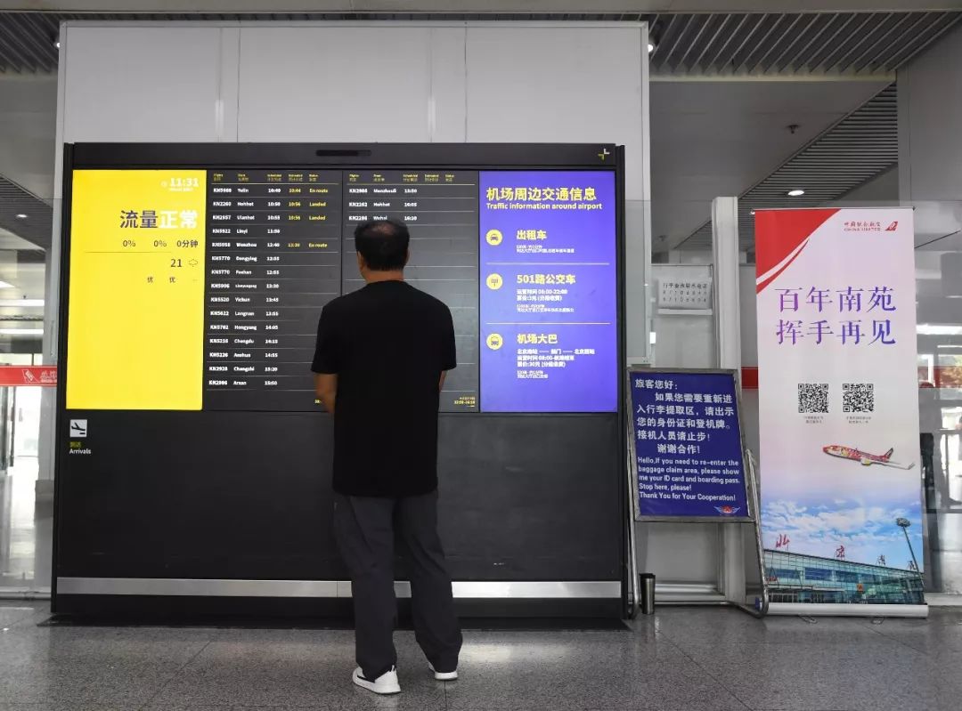 9月25日，市民在北京南苑机场查询航班信息。新华社发（任超摄）