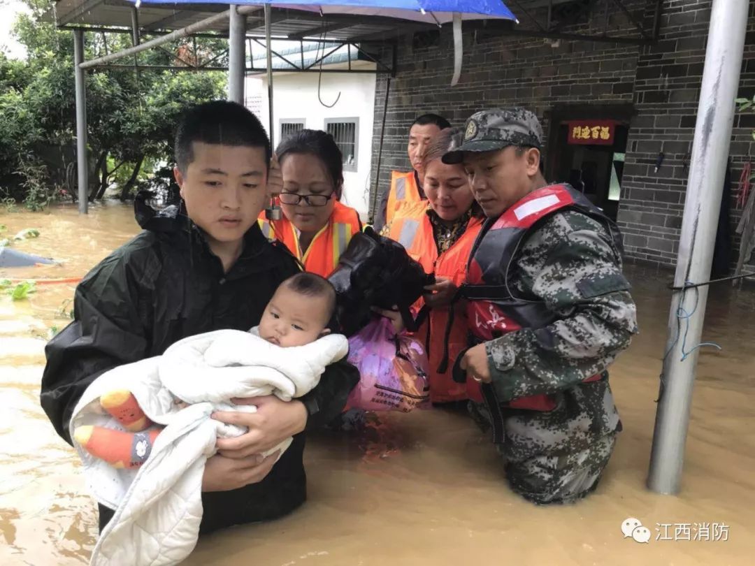 江西吉安多地洪灾 婴儿为消防战士撑伞(图)