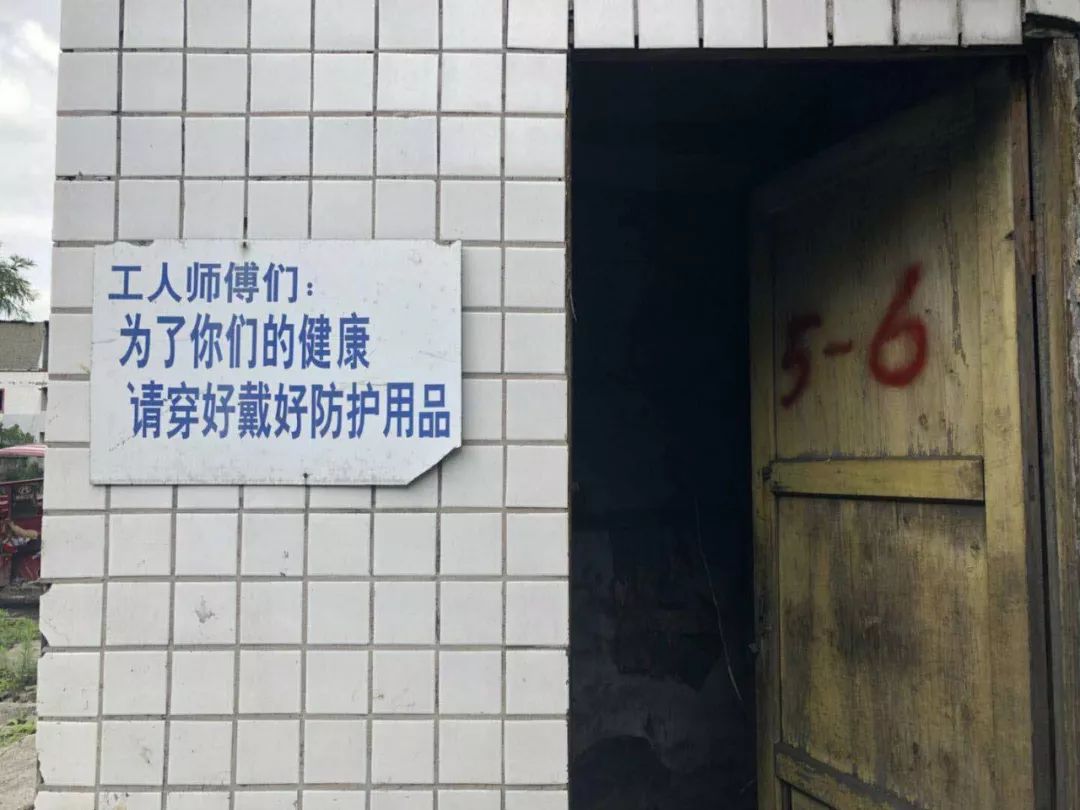  矿区墙上写着提醒工人戴好防护用品的标语。 新京报记者 王翀鹏程 摄