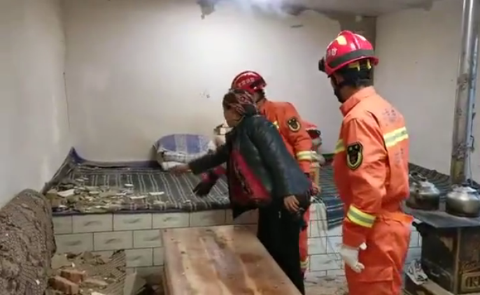 甘肃省消防救援人员正在居民家中查看房屋受损情况。消防供图