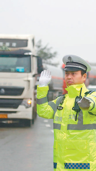 10月6日，在连霍高速陕西省华阴市罗敷收费站，民警指挥危化品车辆有序驶出高速。 　　崔正博摄（影像中国）