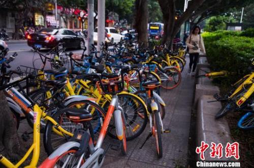 资料图:共享单车占用人行道,行人通过艰难。李南轩 摄