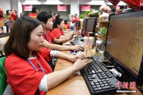 资料图:某电商企业员工们在电脑前解答消费者的购物疑问。中新社记者 陈骥旻 摄