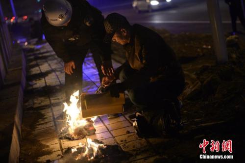 资料图：2017年清明节，呼和浩特市执法人员劝阻民众停止烧纸。中新社记者 刘文华 摄