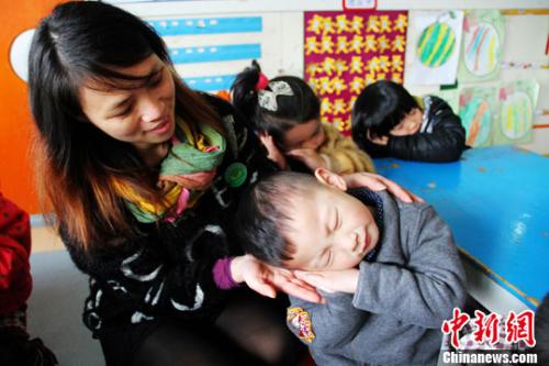 资料图:图为幼儿园老师正在教儿童学“睡觉”。李建平 摄
