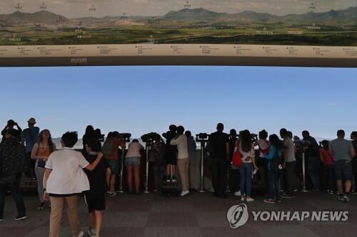 图注：在都罗山瞭望台遥望开城园区的游客（来源：韩联社）