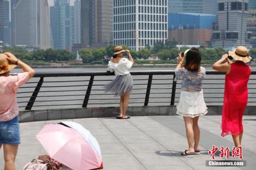 5月16日，游客一身短打行走在上海的街头。当日，上海中心气象台发布了今年第二个高温黄色预警信号。殷立勤 摄