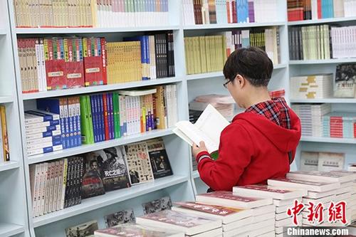 资料图:一女子在某书店选购图书。 中新社记者 于琨 摄