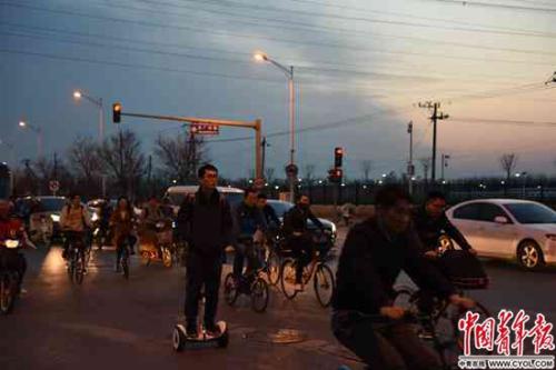 後廠村路路口,一名男子踩着電動平衡車過馬路。據說這裏以名字土和堵車聞名。實習生 楊子怡 攝
