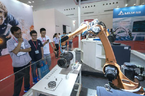 6月5日，参观者在展会上参观展出的工业机器人。当日，2018中国（武汉）国际自动化与机器人展览会在武汉国际博览中心开幕。（新华社）