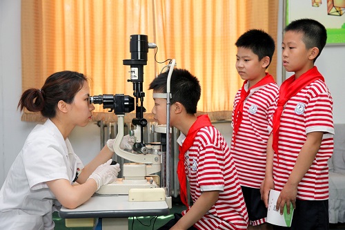 2018年6月6日，在石家庄市西里小学，医护人员为小学生进行视力检查。