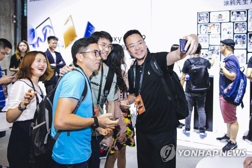 资料图:8月15日,在中国上海,当地居民在三星电子新款手机发布会上进行体验。