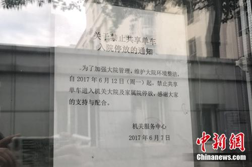 某单位大门贴出的“禁止共享单车入院停放”通知。中新网 吴涛 摄