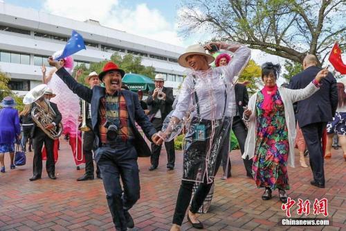 資料圖片:中國遊客參加“墨爾本賽馬節”。圖爲一對來自中國的夫婦伴着樂隊的音樂和歌聲,與一位澳大利亞工作人員共舞。<a target='_blank' href='http://www.chinanews.com/'>中新社</a>記者 陶社蘭 攝