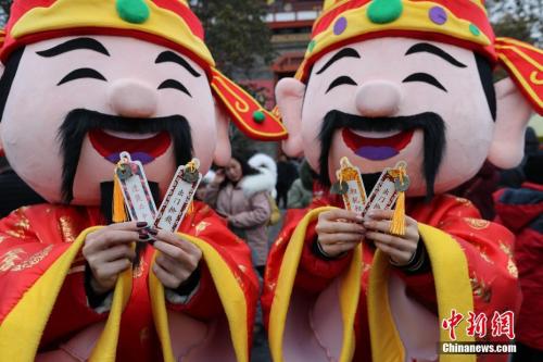 资料图:“财神”展示红包里的“宋钱”。 王中举 摄