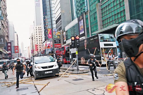 香港警察冲破旺角弥敦道的路障，下车拘捕多名涉嫌堵路的蒙面暴徒。（香港文汇报）