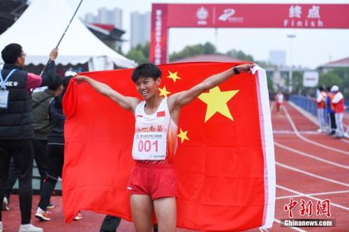 图为军事五项越野跑比赛结束后中国选手卢嫔嫔举起国旗庆祝。中新社记者 何蓬磊 摄