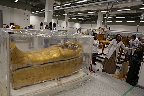  在大埃及博物馆文物保护中心，工作人员在古埃及法老图坦卡蒙外层木质镀金棺旁工作。（新华社）
