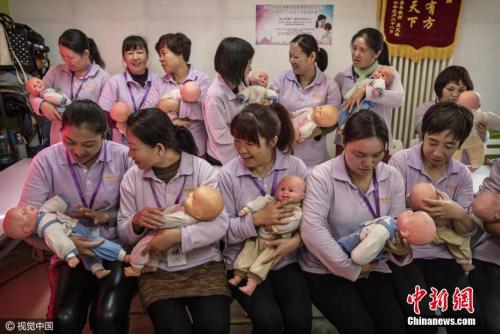 资料图:北京某培训机构,妇女们在参加月嫂培训。 图片来源:视觉中国