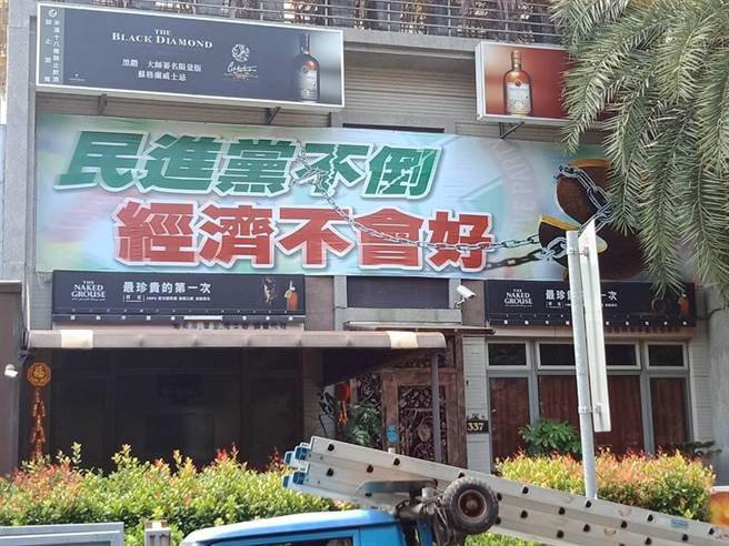 高雄知名餐厅外悬挂的“民进党不倒,经济不会好”海报(图片来源:中评社)