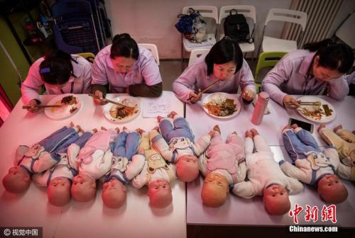 资料图:妇女们参加阿姨大学的月嫂培训课程。 图片来源:视觉中国