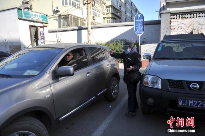  北京市某停车场管理员为车主指挥倒车。中新网记者 金硕 摄