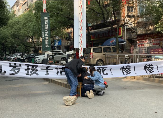 ▲11月8日上午,罗鸣妈妈趴在小区门口儿子的遗像前。新京报记者 付子洋 摄