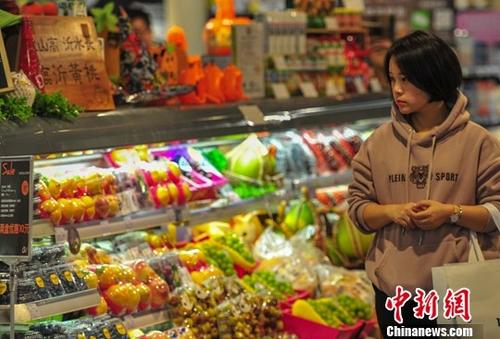 资料图:10月16日,一名消费者在超市选购商品。中新社记者 于海洋 摄
