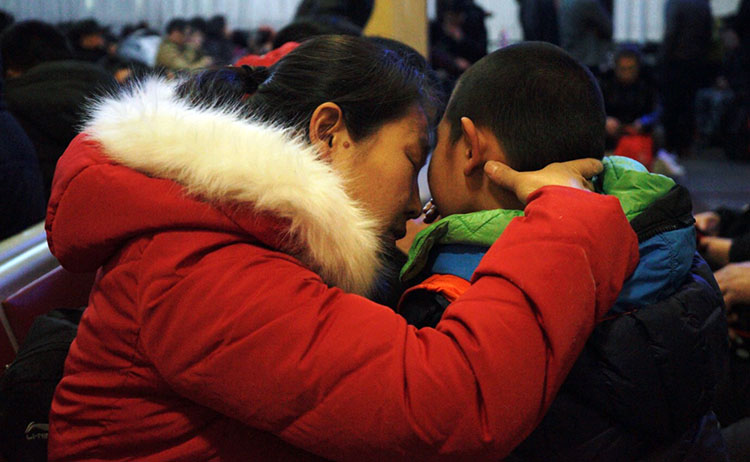 1月20日晚，北京火车站候车室，一位母亲在安抚因漫长等待而烦躁的孩子。