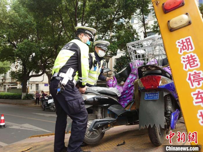 对违法占道停放的非机动车进行现场拖车。 唐娟 摄