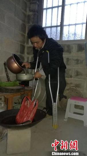 图为覃国英在淘米 覃炳陆 摄