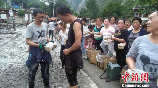 图为受灾村民排队吃饭。 董超 摄