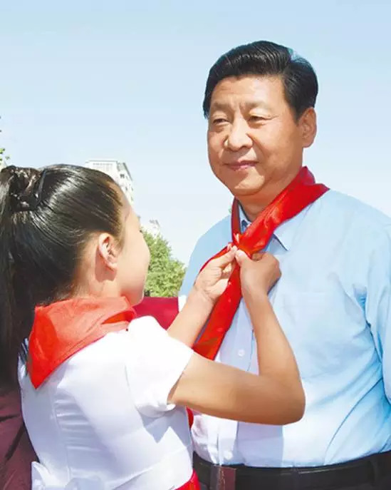 2013年5月29日，中共中央总书记、国家主席、中央军委主席习近平在北京市少年宫参加“快乐童年 放飞希望”主题队日活动。这是少先队员为习近平佩戴上红领巾。