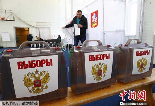 当地时间3月18日，一名男子走出投票处，准备将选票向入记票箱。当日，俄罗斯迎来总统选举日。