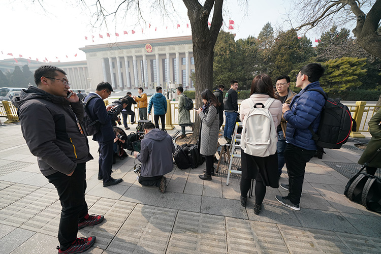 人民大会堂东门外等候入场的记者。