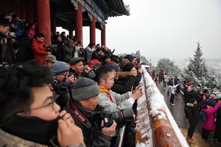 景山万春亭前挤满赏雪的游客。