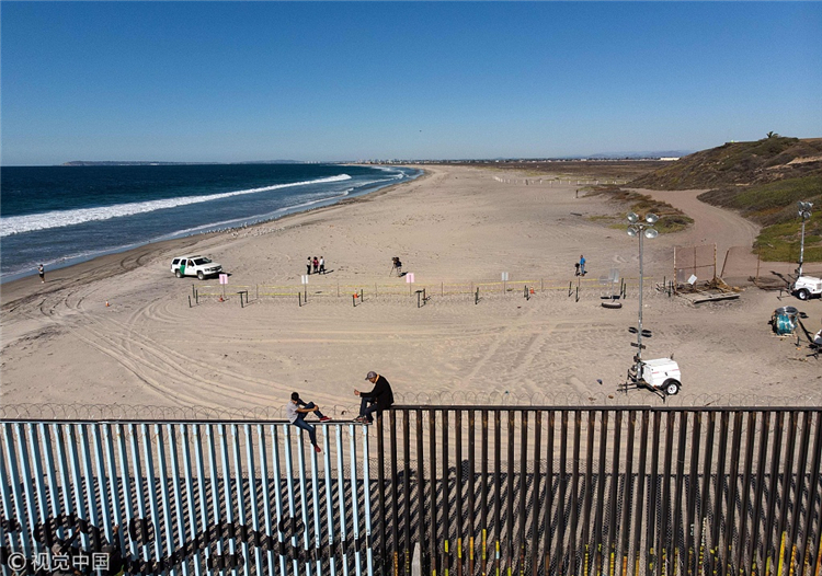 咫尺天涯!中美洲移民攀爬美墨边境墙眺望美国