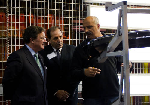 加拿大一家汽车系统工厂生产车间的工作人员（右）向外界介绍生产情况。新华社