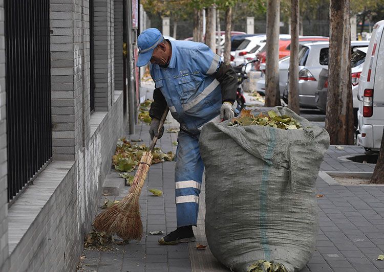 东九路,一名环卫工人在寒风中清扫落叶。