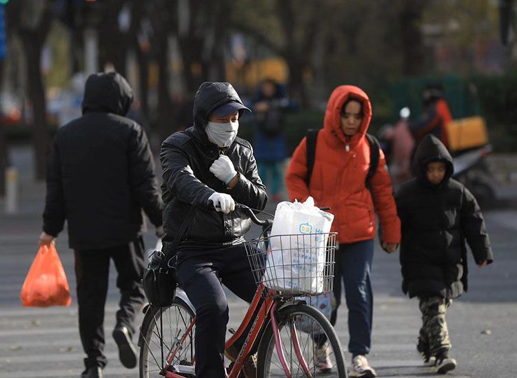 知春路,一位骑车人在寒风中扎紧领口。