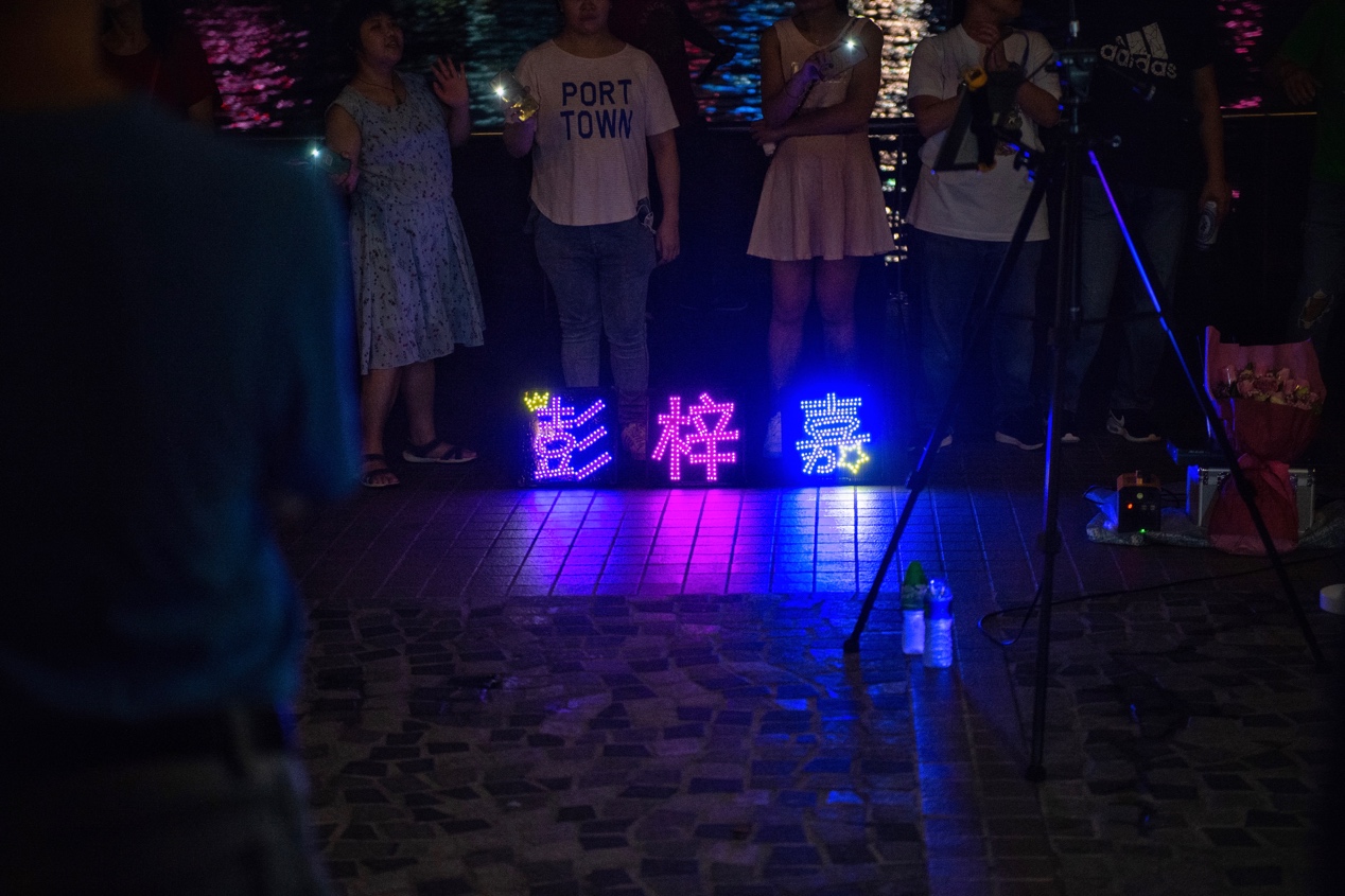 维多利亚港，听歌的粉丝们带来了彭梓嘉名字的灯牌。