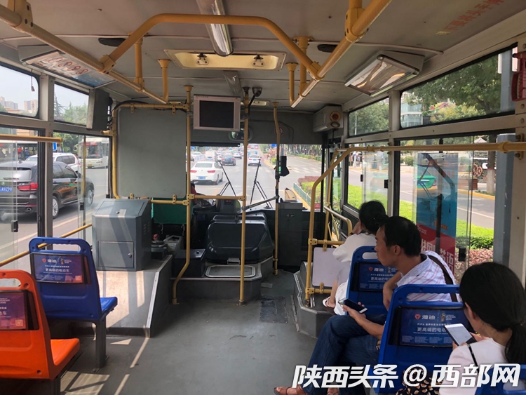 无空调公交上,乘客选择阴凉一边就座。
