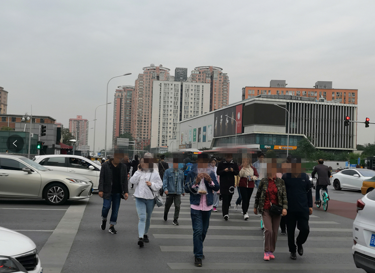 朝阳大悦城路口,不少行人过马路玩手机