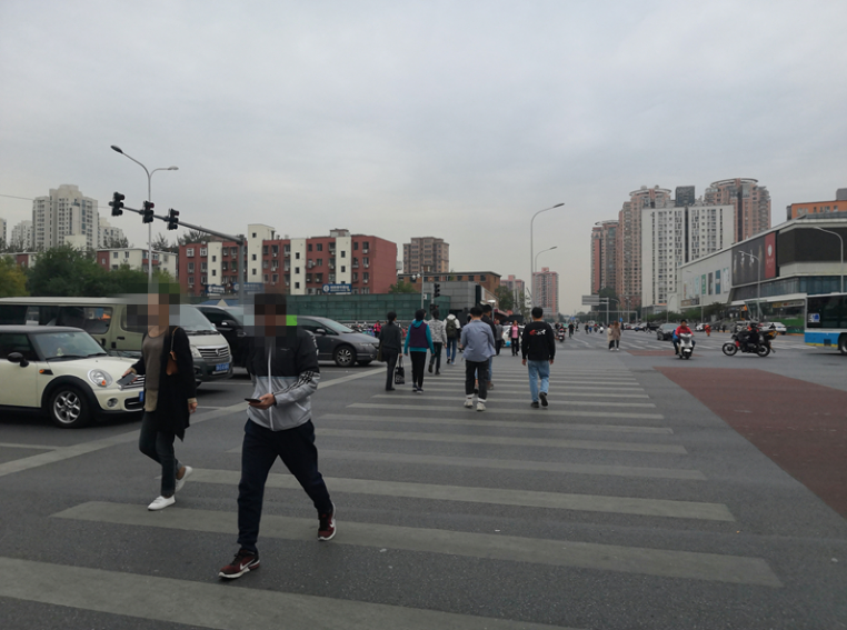 一名男子过马路时低头看着手机