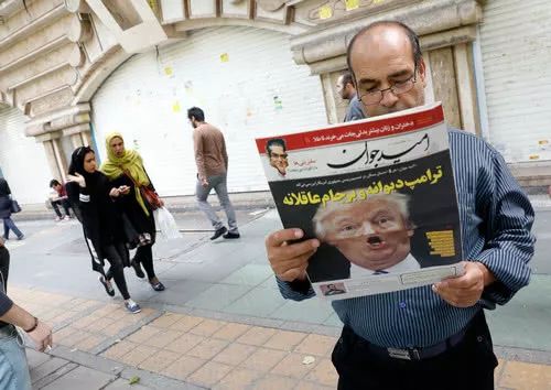 一名伊朗男子手持刊載川普關於伊核協議講話的報紙，標題爲“瘋狂的川普”。（法新社）